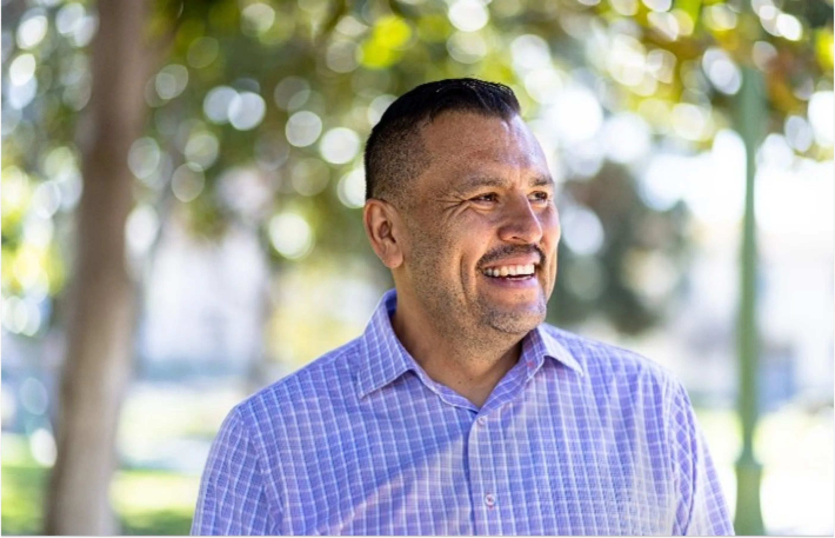 Adult male standing outdoors smiling