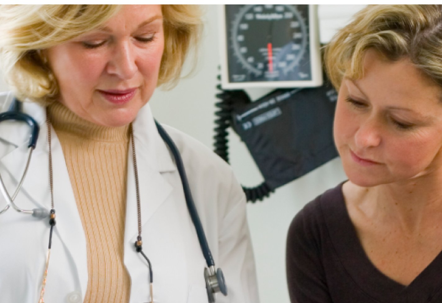 Female doctor speaking with a female patient in an examination room