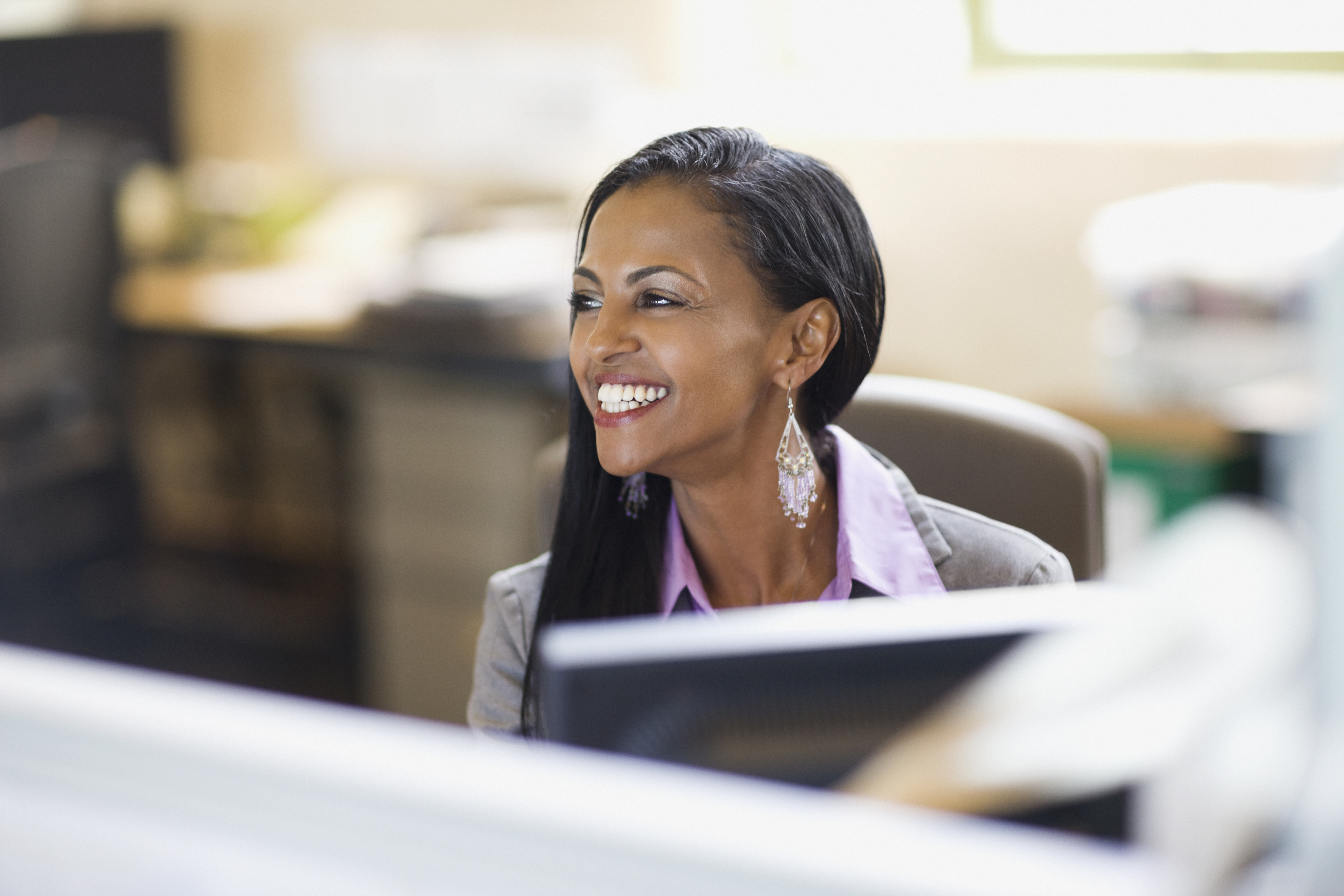 smiling female employee sitting at a computer