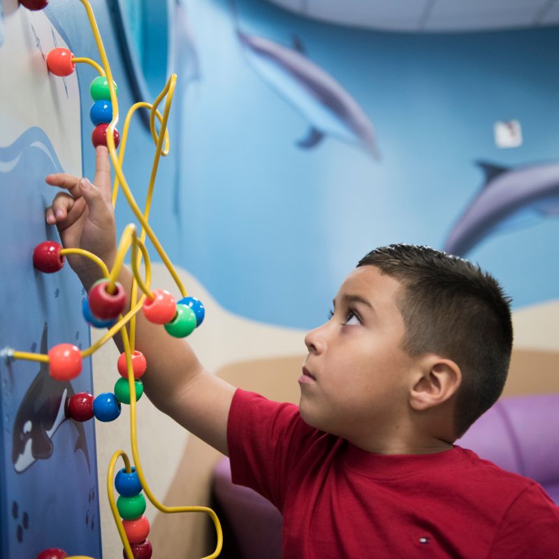 A young boy is playing with toys in the lobby of Novant Health Hemby Children's Hospital.